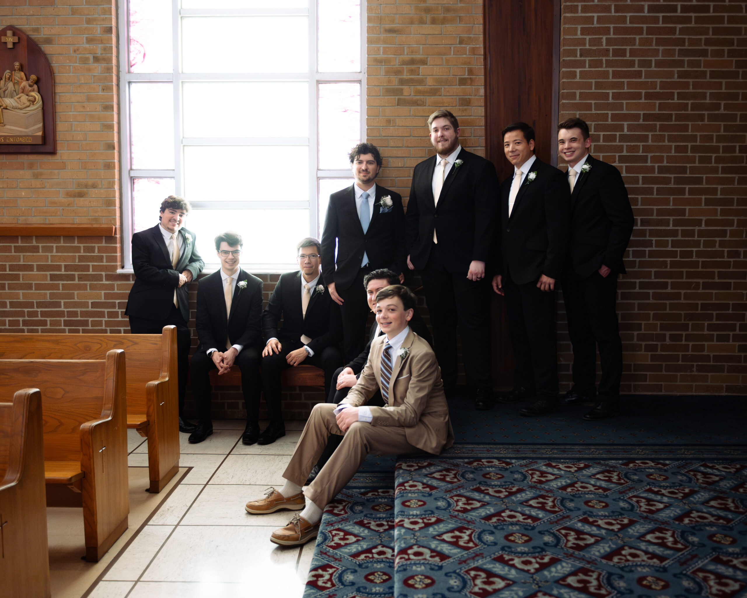 a groom and his groomsmen pose for an editorial style portrait at holy spirit catholic church in huntsville, al