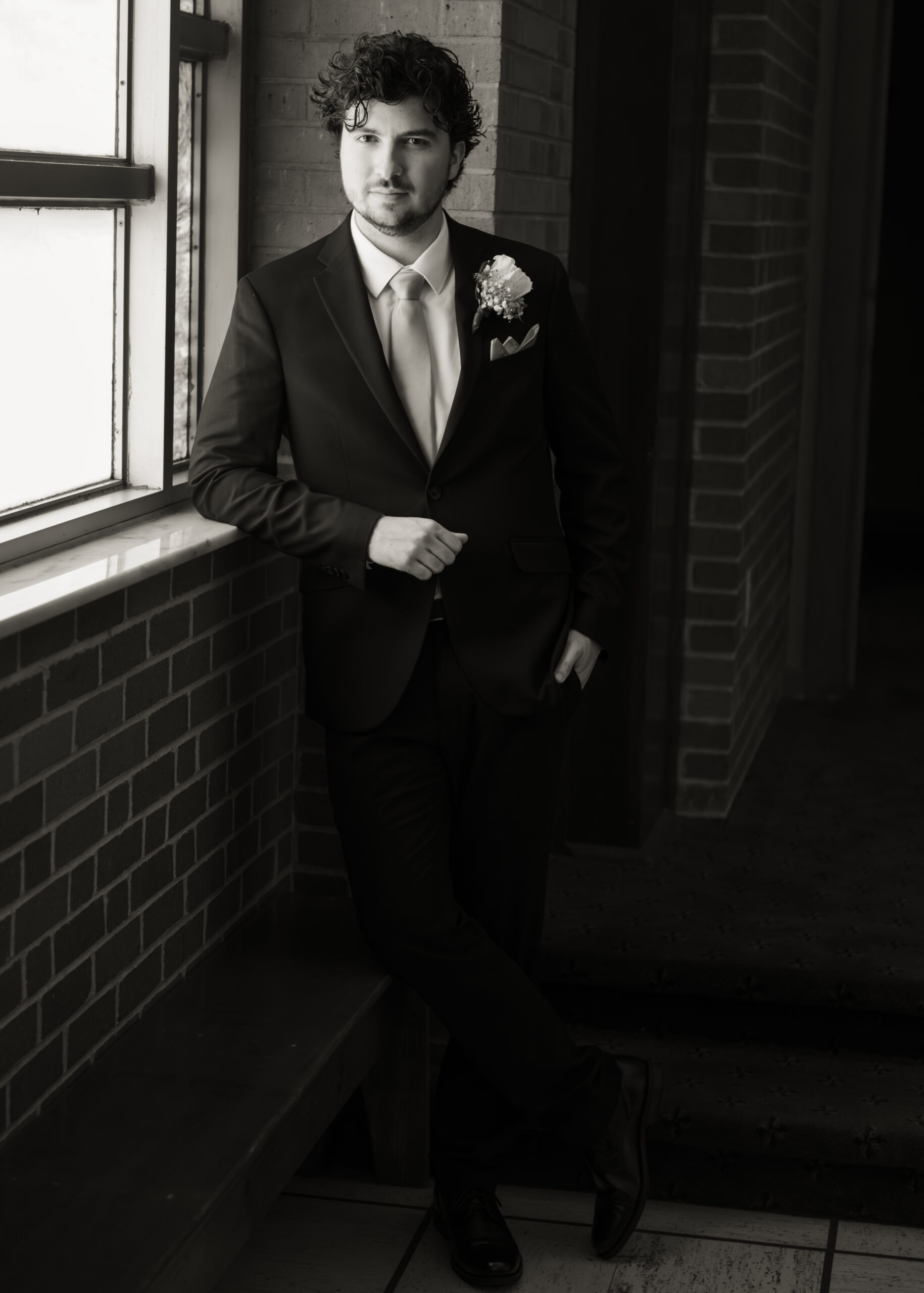 a moody black and white grooms portrait before his catholic wedding mass in huntsville alabama
