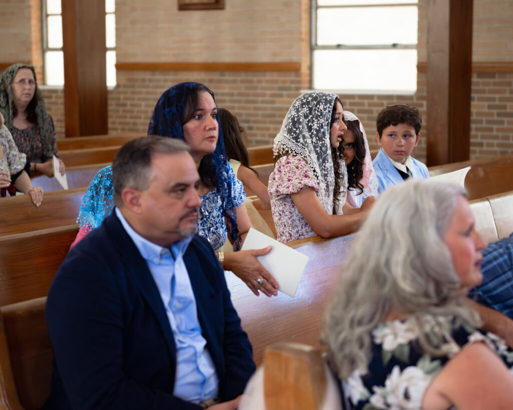 wedding guests pray a rosary for a couple getting married at holy spirit catholic church in huntsville, alabama