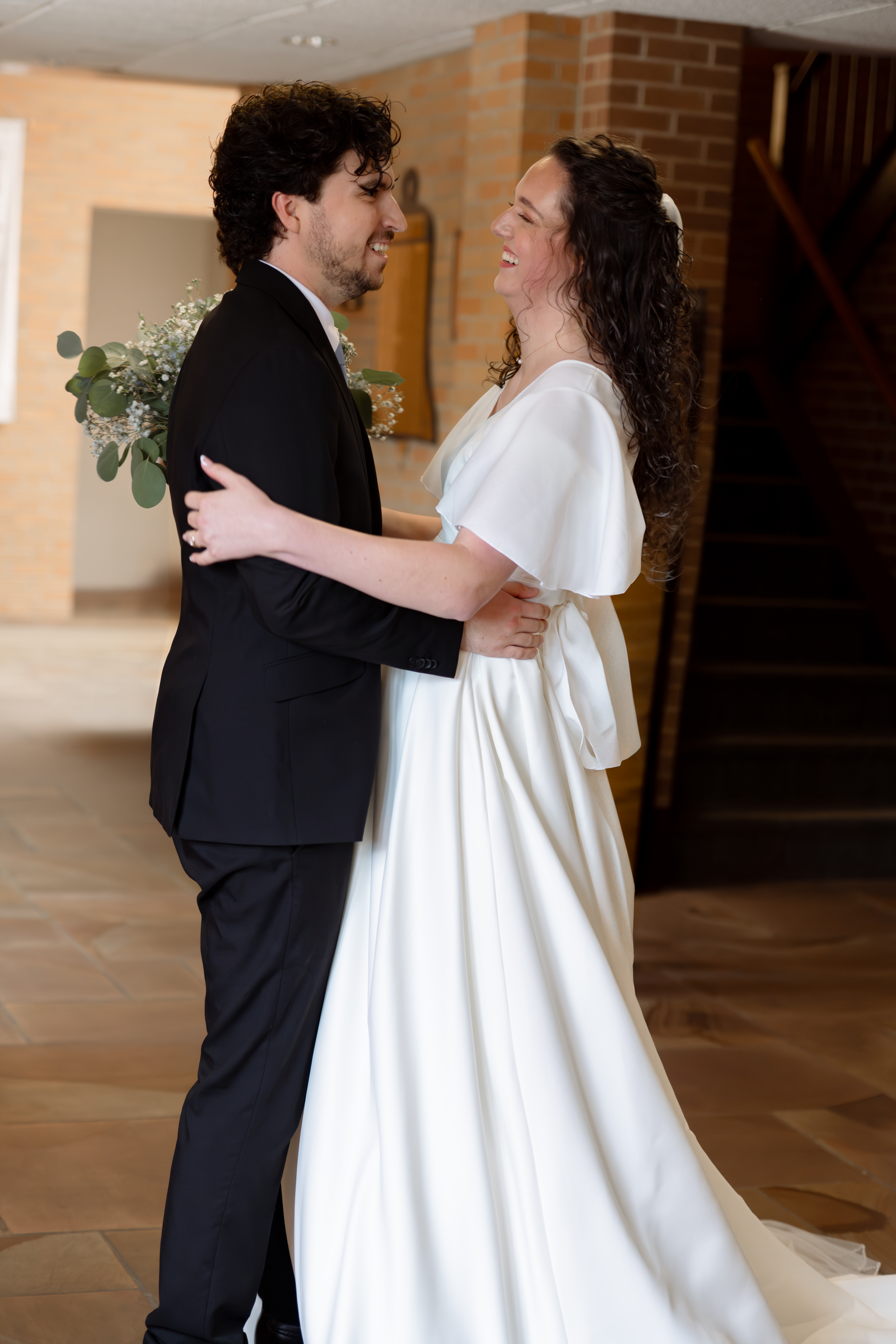 A catholic bride and groom joyfully embrace outside the sanctuary of Holy Spirit Catholic Church in Huntsville, Alabama immediately following their catholic wedding mass