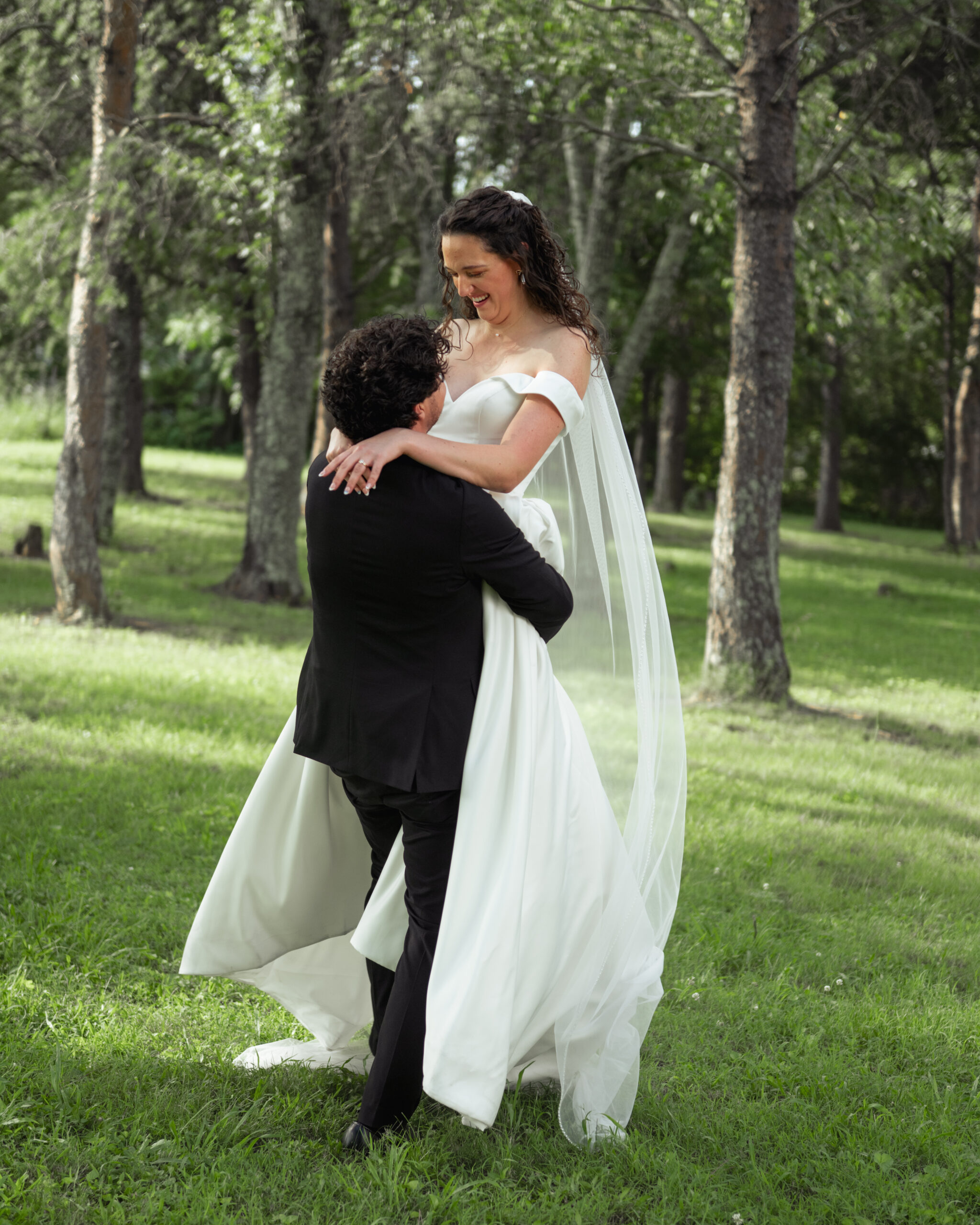 A catholic groom lifts and spins his new bride outside their reception venue in athens, alabama