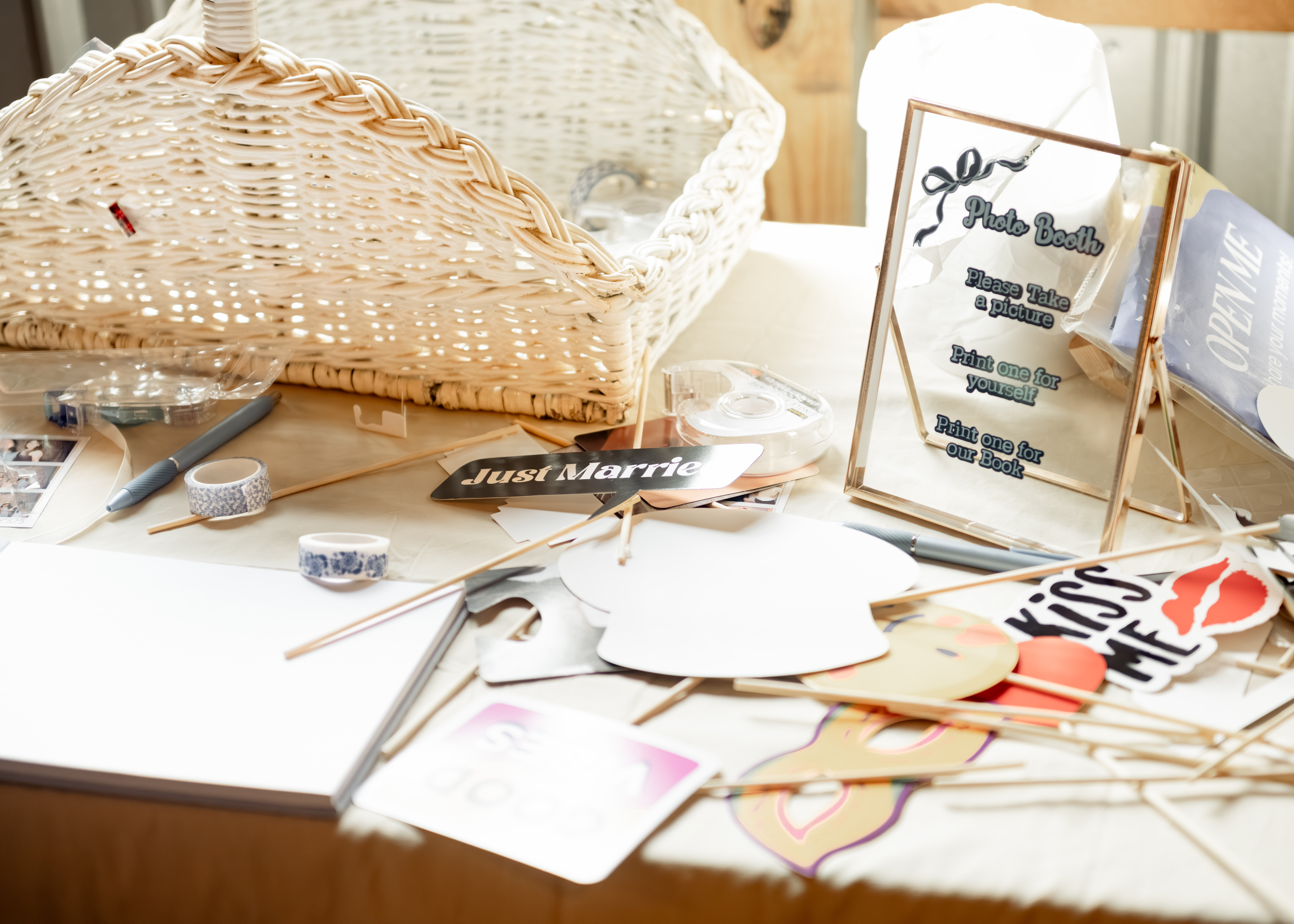 photobooth props sit on a sunny table at southern charm in athens, alabama during a catholic wedding reception
