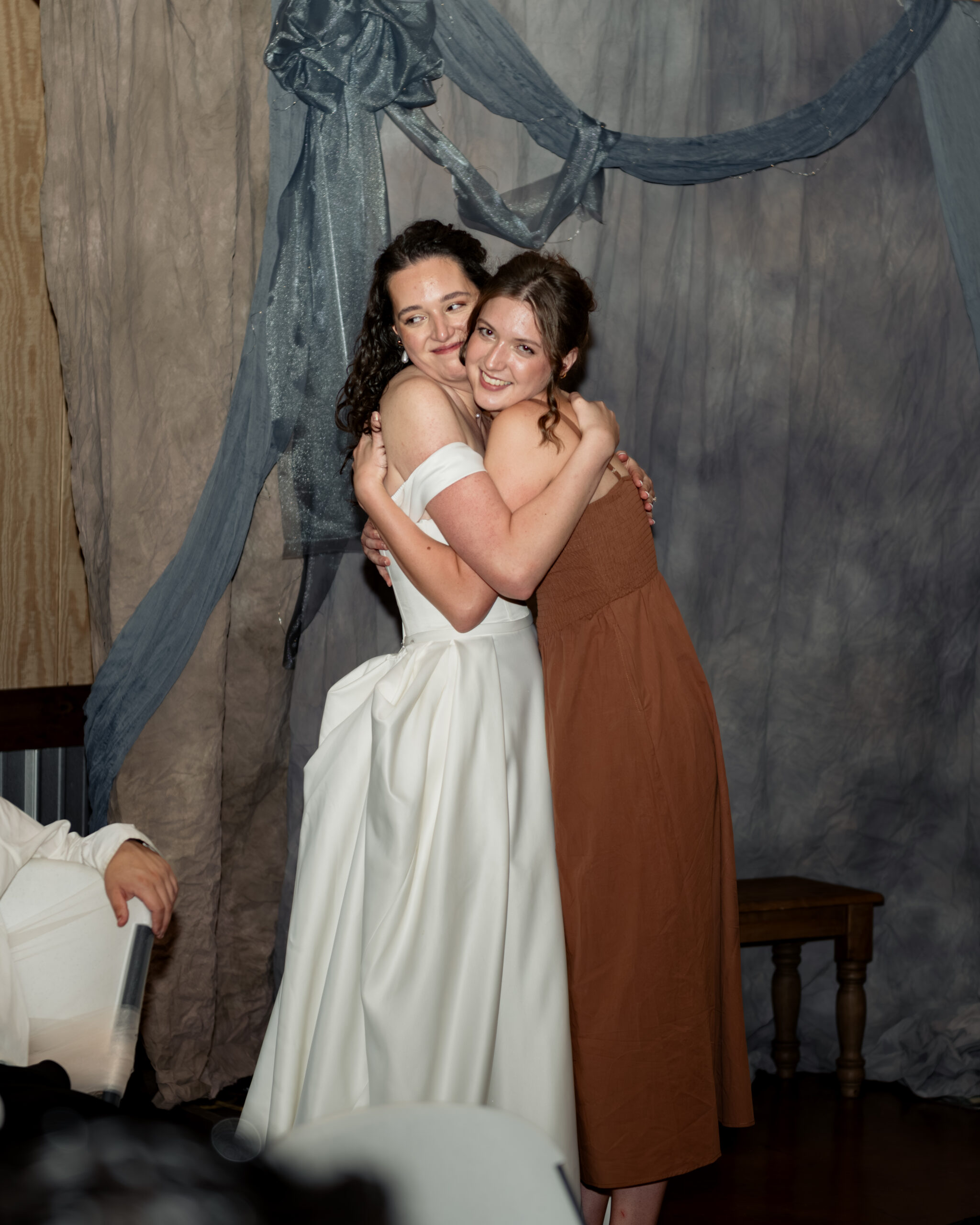 The bride embraces her sister after a toast during a large catholic wedding reception at southern charm in athens, alabama