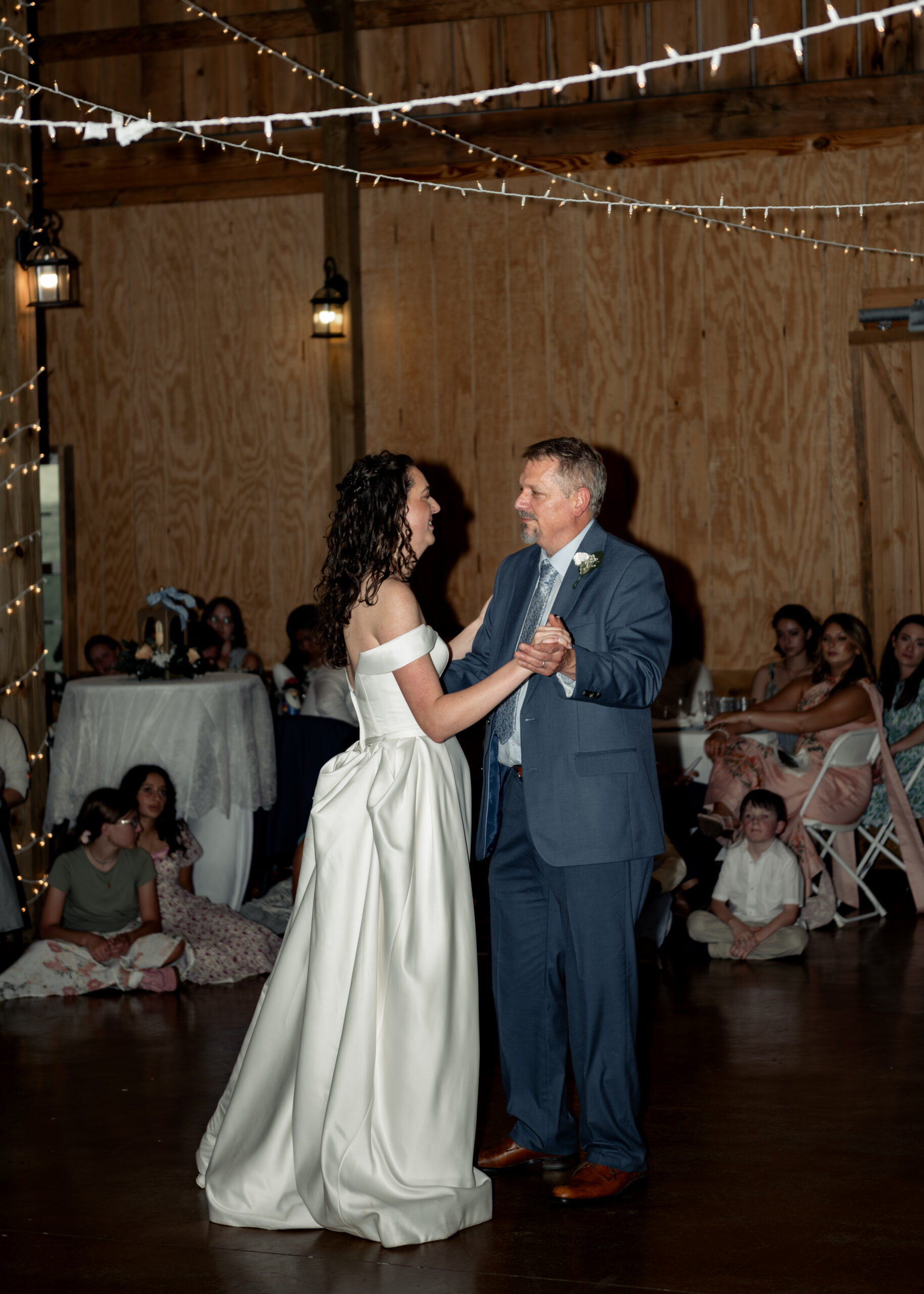 A catholic bride joyfully dances with her father at a large catholic wedding reception at southern charm in athens, alabama