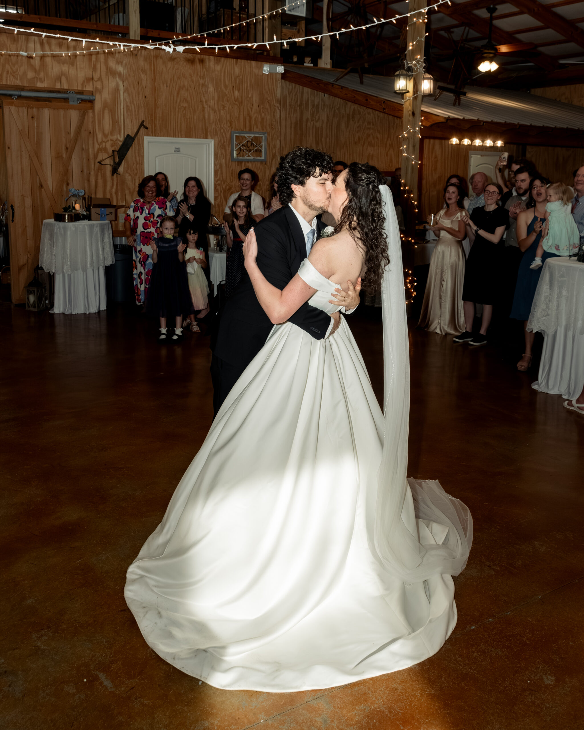 a catholic bride and groom joyfully enter their wedding reception and kiss each other at Southern Charm in Athens, alabama