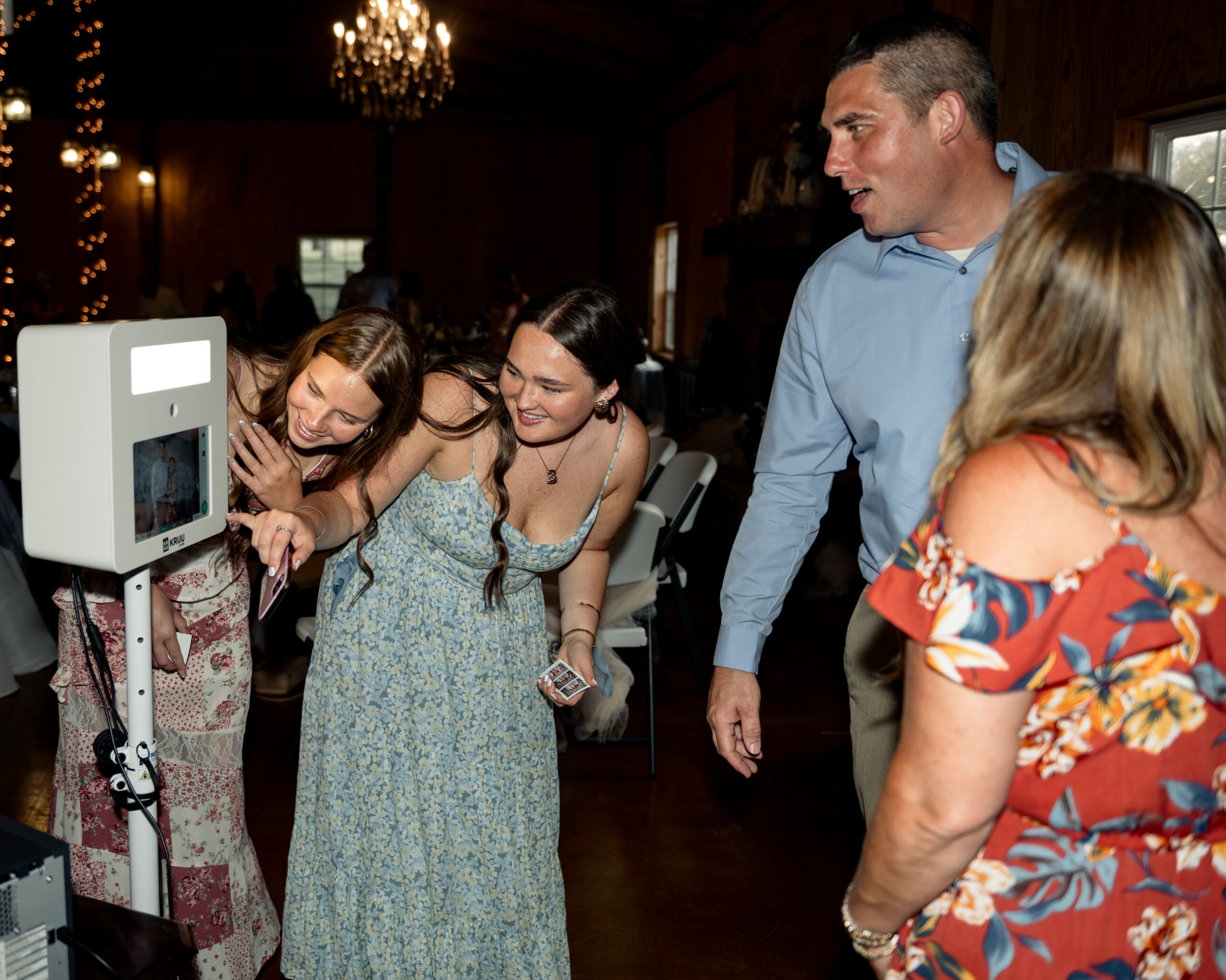 guests enjoy the provided photo booth at a large catholic wedding reception at southern charm in athens, alabama