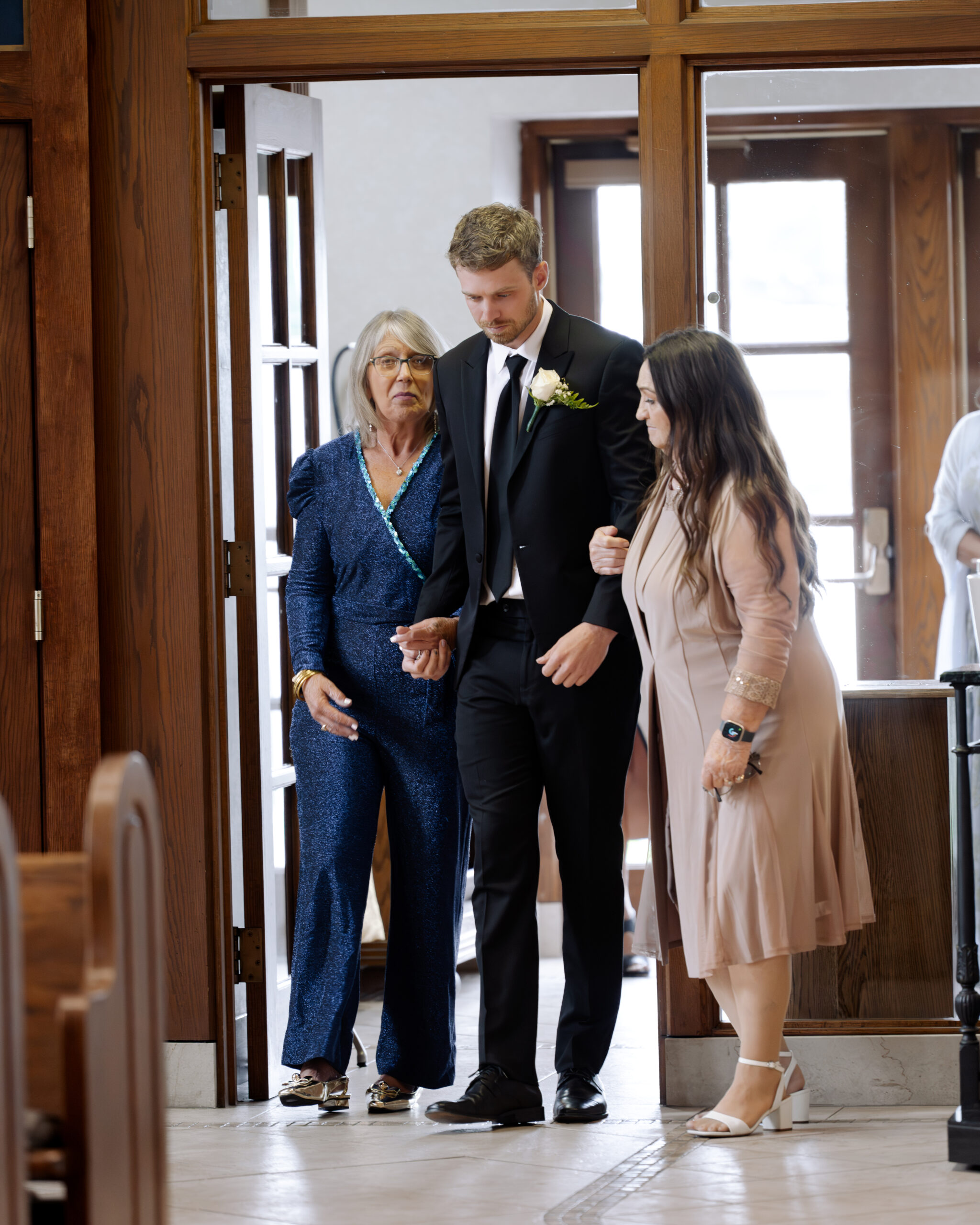 A groom walks his family members down the aisle during a catholic wedding ceremony at St. Ann's Catholic Church in Nashville, TN