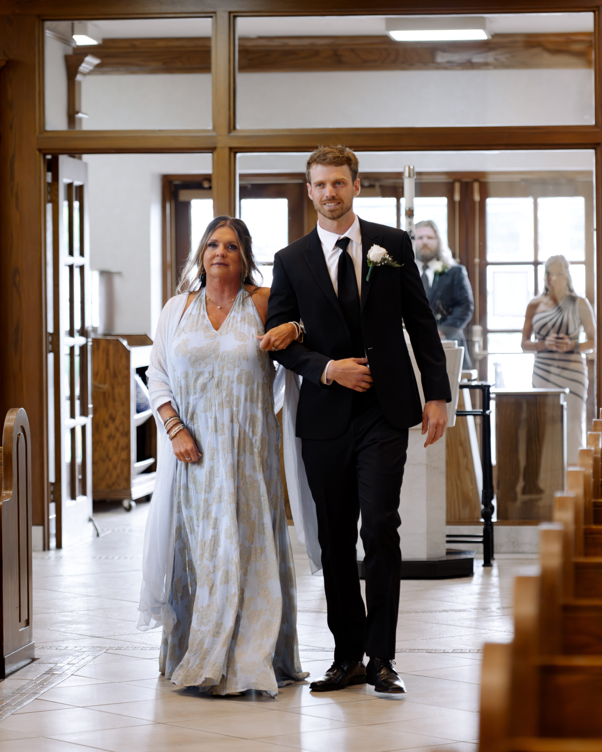 The groom walks his tearful mother down the aisle at a catholic wedding ceremony at St. Ann's Catholic Church in Nashville, TN