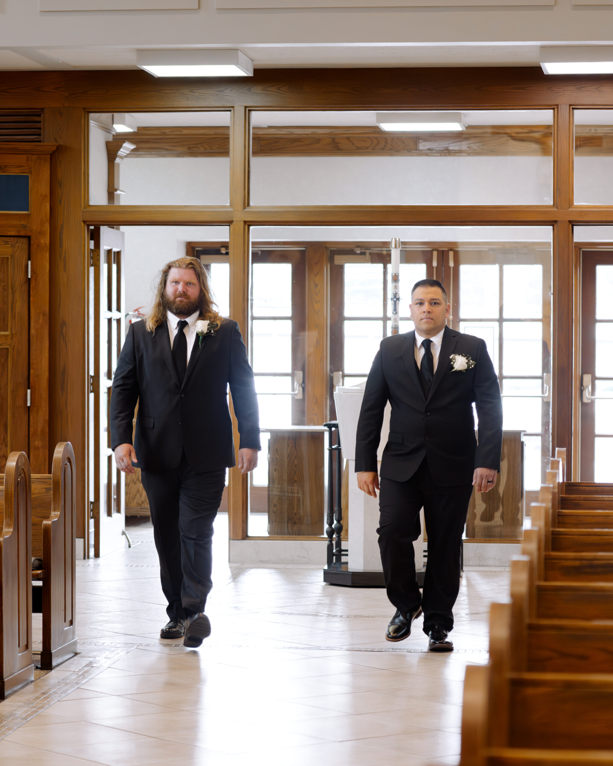 The brothers of the catholic bride and groom walk down the aisle during a catholic wedding ceremony at St. Ann's Catholic Church in Nashville, TN