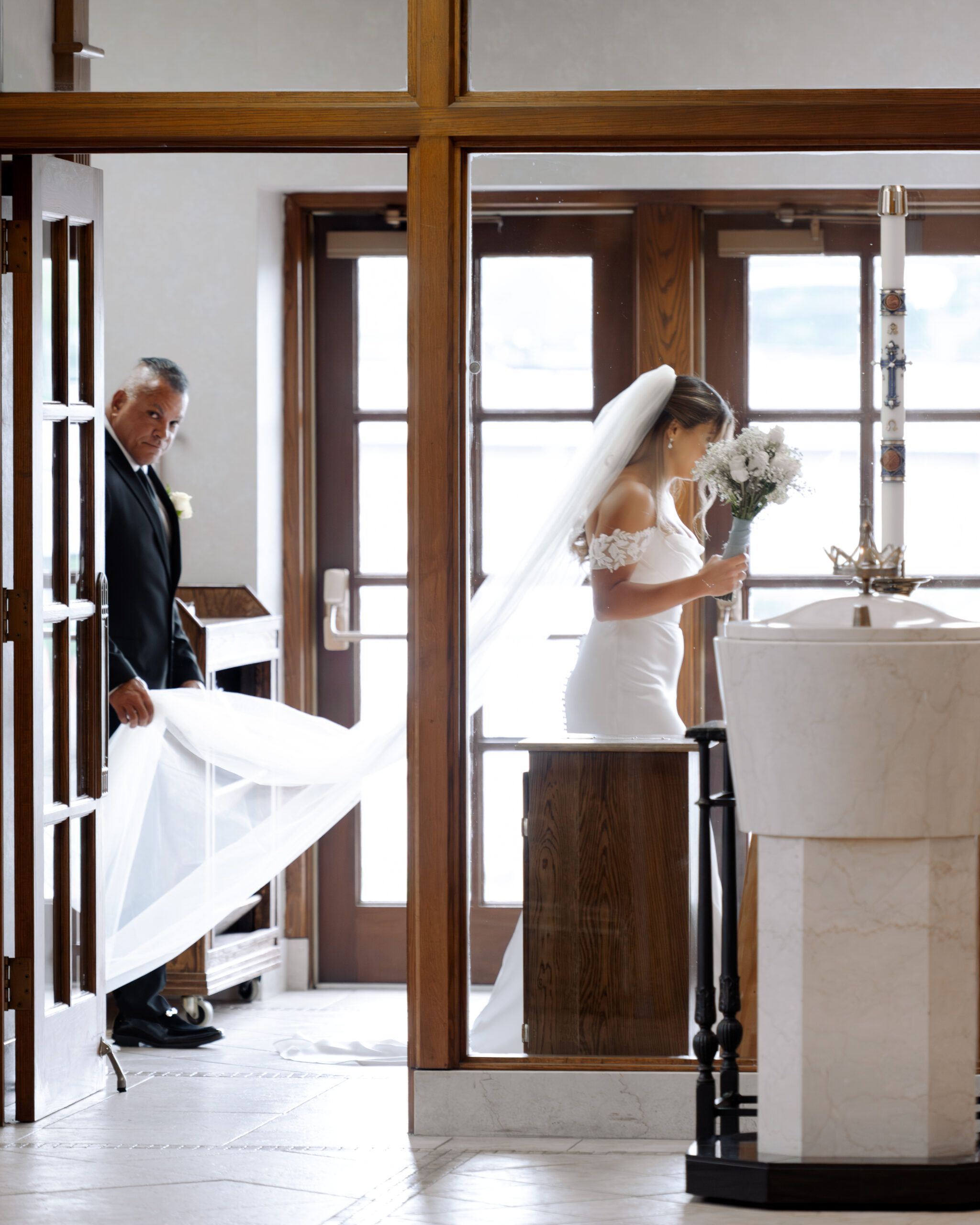 A catholic bride and her father prepare to walk down the aisle during a catholic wedding ceremony at St. Ann's Catholic Church in Nashville, TN