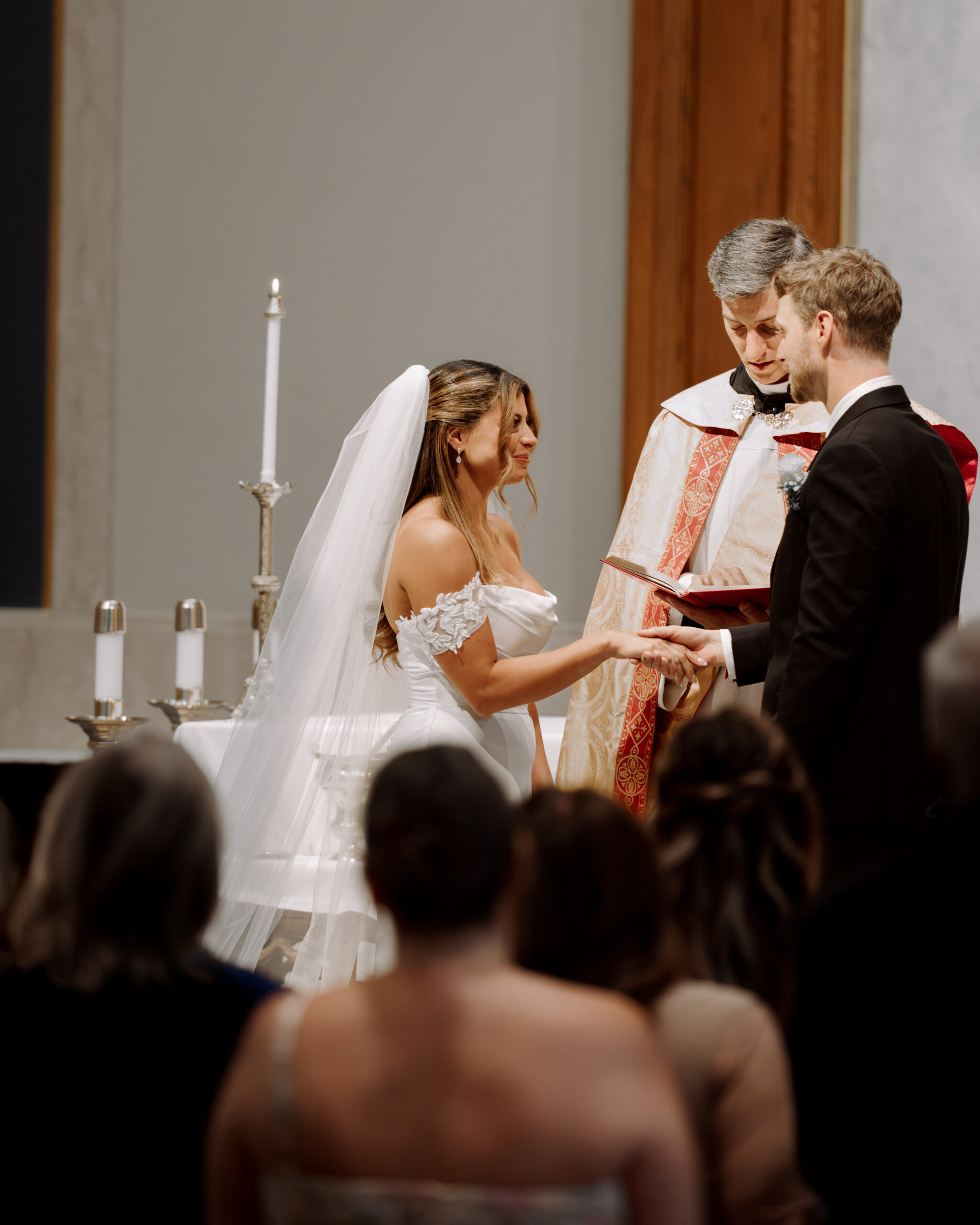 A catholic bride and her groom exchange vows during a catholic wedding ceremony at St. Ann's Catholic Church in Nashville, TN