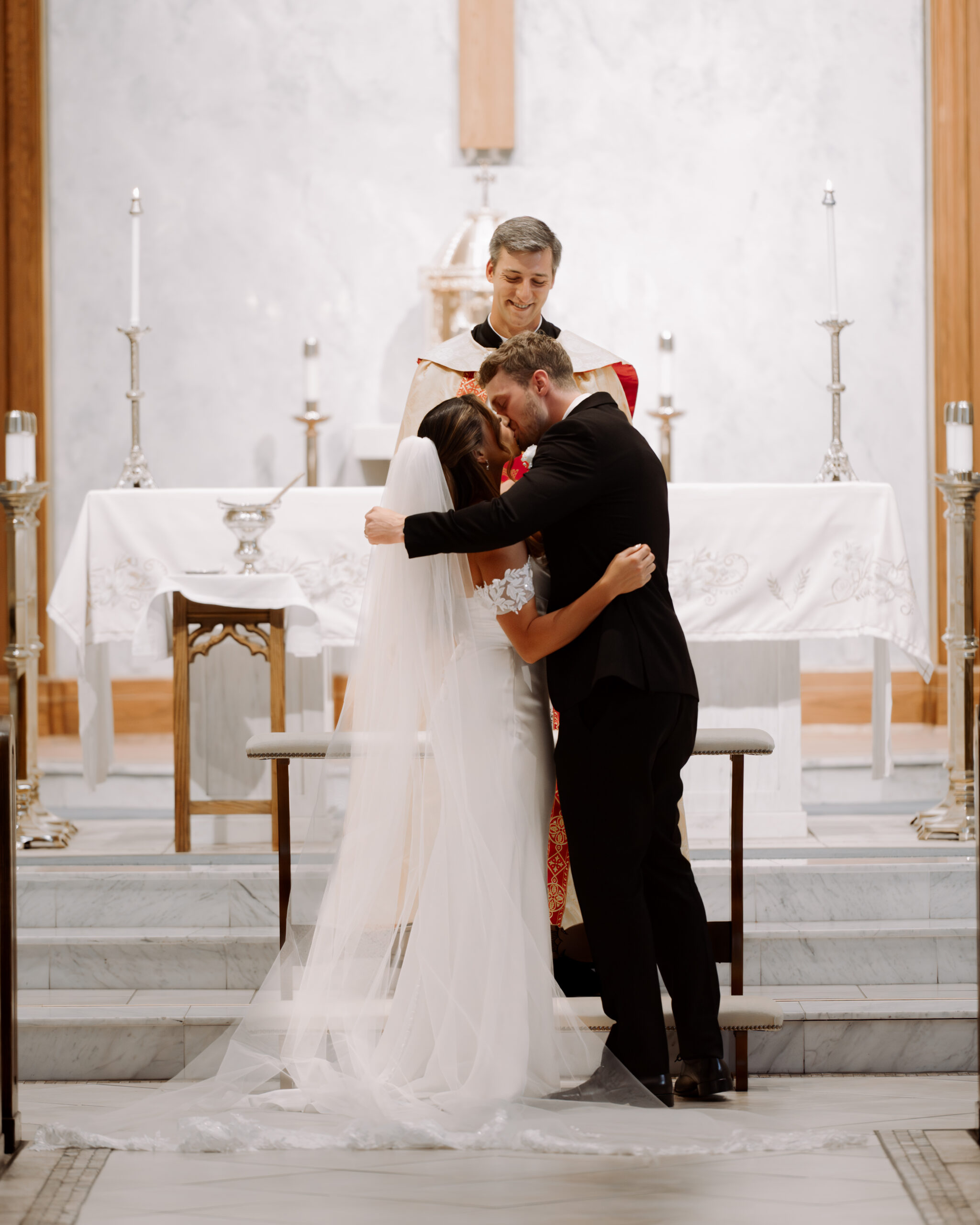 A catholic bride and groom share a dramatic first kiss during a catholic wedding ceremony at St. Ann's Catholic Church in Nashville, TN