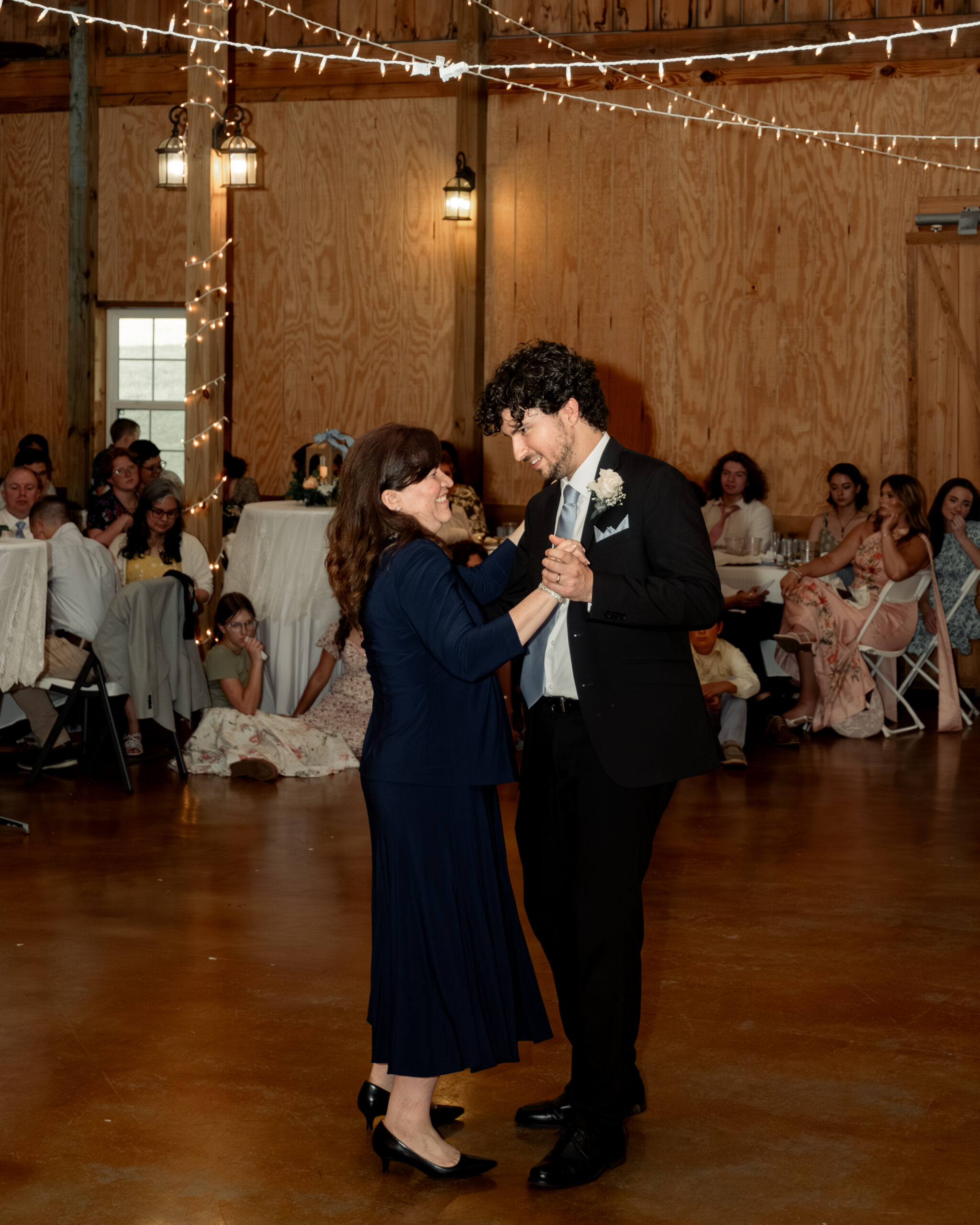 A catholic groom joyfully dances with his mother at a large catholic wedding reception at southern charm in athens, alabama