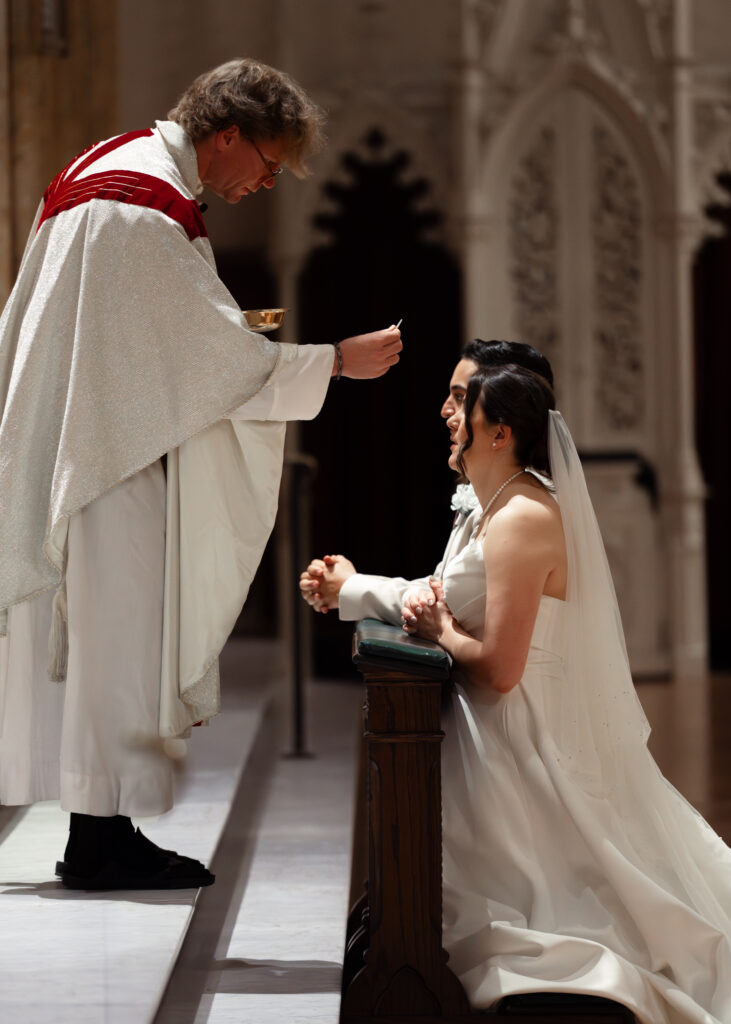 A catholic bride and groom receive communion during their wedding at st. boniface catholic church in downtown louisville, kentucky